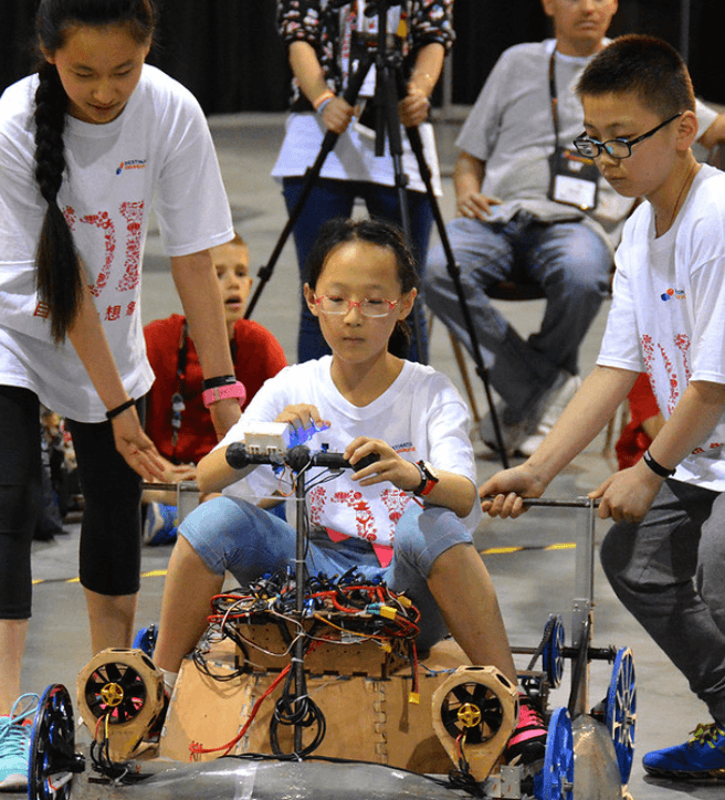 Students testing a hand-built vehicle at a DI tournament